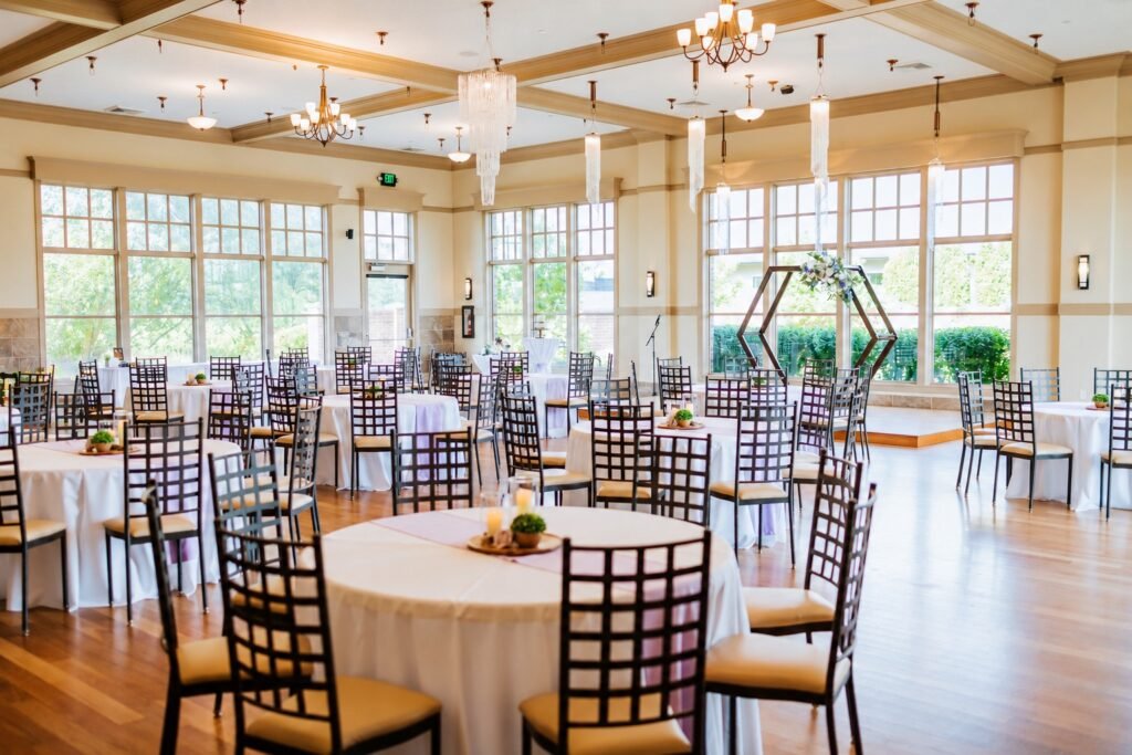 Ballroom at Bravo Event Center, a wedding reception venue in Utah County, set with round tables and chandeliers